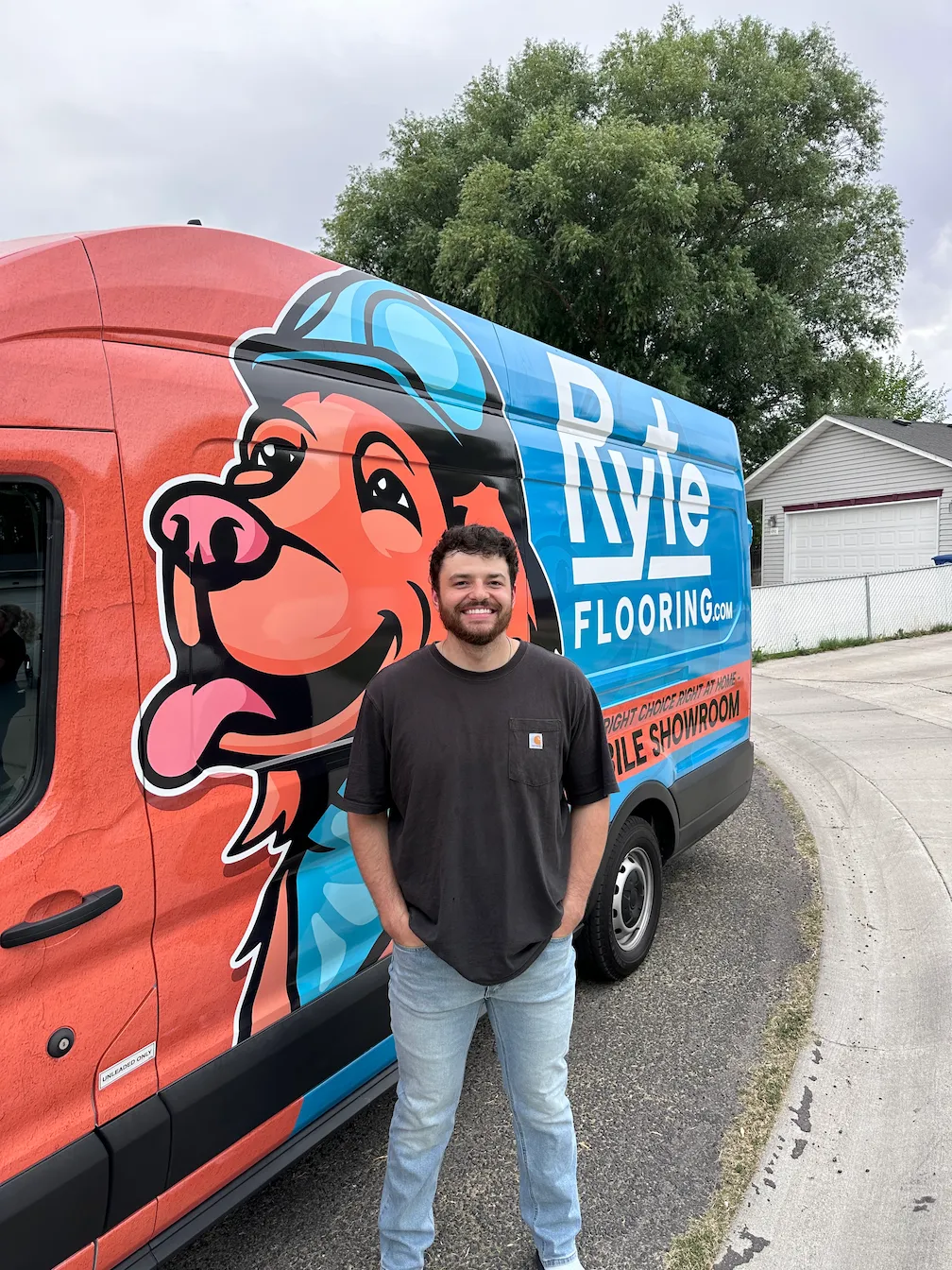 ryte-flooring-satisfied-customer-success A smiling customer standing by the Ryte Flooring mobile showroom van, showcasing successful residential flooring installation in Twin Falls.