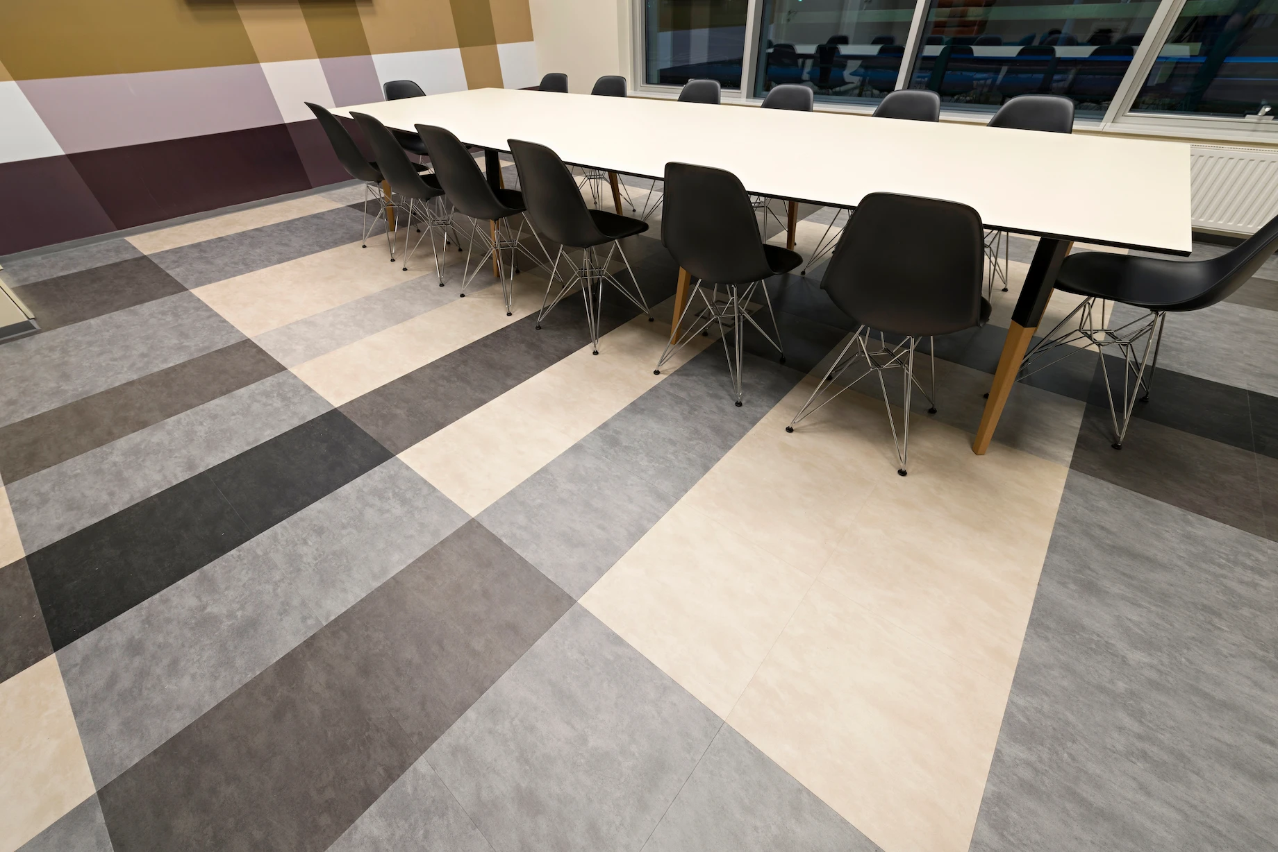 Modern commercial LVT flooring installation in a large conference room with geometric patterns.